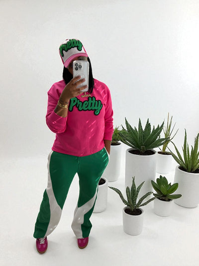 Person wearing a pink and green outfit with plants in the background