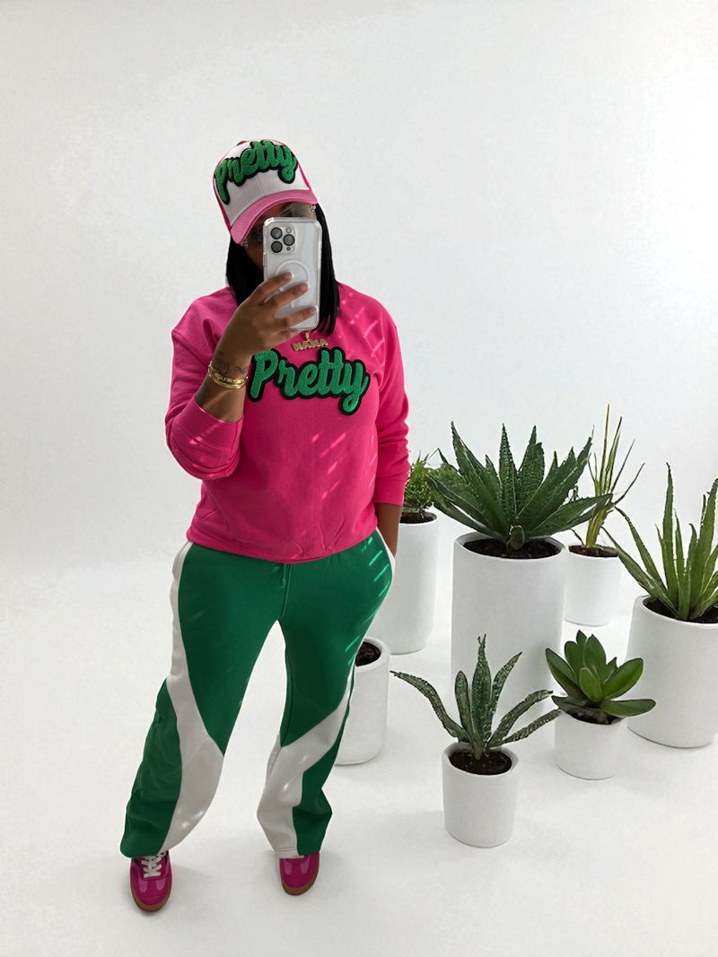 Person wearing a pink and green outfit with plants in the background
